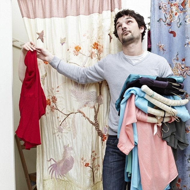 Man holding clothes by a changing room